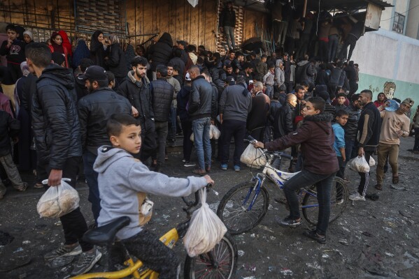 في الصورة الملتقطة يوم الاثنين 19 فبراير 2024، حشود فلسطينية تكافح لشراء الخبز من مخبز في رفح بقطاع غزة. وتقول وكالات الإغاثة الدولية إن غزة تعاني من نقص الغذاء والدواء والإمدادات الأساسية الأخرى نتيجة للحرب بين إسرائيل وحماس. .  (صورة AP/ محمد دهمان)