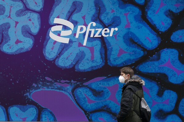 ملف – رجل يسير بالقرب من مقر شركة فايزر، الجمعة 5 فبراير 2021 في نيويورك.  أصدرت شركة Pfizer توقعات مالية للعام المقبل لا تتوافق مع توقعات وول ستريت مع انخفاض مبيعات منتجات COVID-19.  تراجعت الأسهم بأكثر من 7٪ قبل جرس الافتتاح الأربعاء 13 ديسمبر 2023. (AP Photo / Mark Lennihan، File)