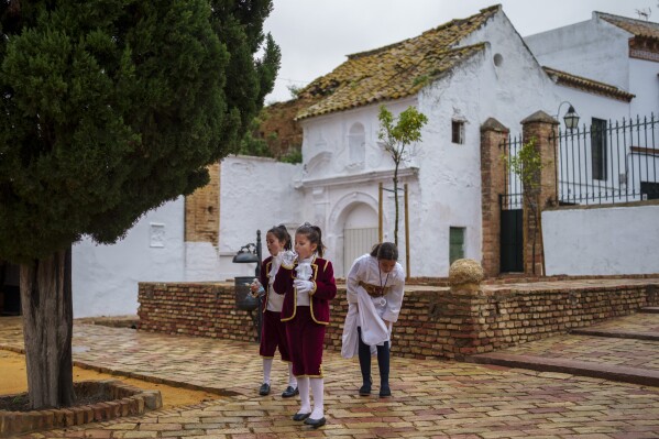 ملف – التائبون من الأخوة الكاثوليكية “Quinta Angustia de Carmona” يقفون خلال موكب الأسبوع المقدس الذي تم إلغاؤه بسبب المطر، في كارمونا، جنوب إسبانيا، الأربعاء، 27 مارس، 2024. (AP Photo / Manu Fernandez، File)