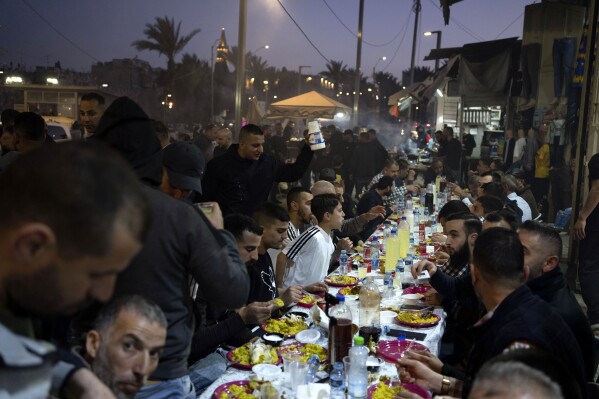 المسلمون يفطرون بوجبة الإفطار بعد صلاة الجمعة الأخيرة من شهر رمضان المبارك، خارج البلدة القديمة في القدس، 5 أبريل، 2024. (AP Photo / Leo Correa)