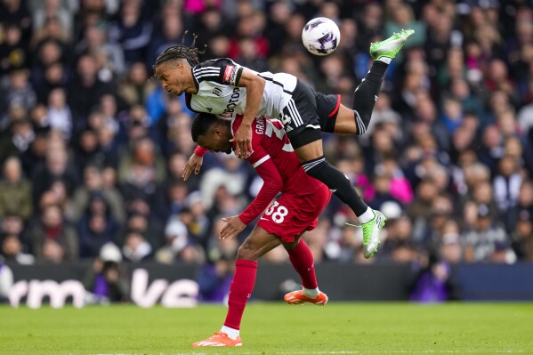 لاعب فولهام بوبي ديكوردوفا-ريد، في الأعلى، يتنافس على الكرة مع لاعب ليفربول رايان جرافنبرتش خلال مباراة كرة القدم في الدوري الإنجليزي الممتاز بين فولهام وليفربول في ملعب كرافن كوتيدج في لندن، الأحد 21 أبريل 2024. (AP Photo / Kirsty Wigglesworth)