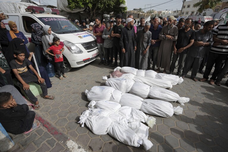 فلسطينيون يصلون بجوار جثث أقاربهم الذين قتلوا في قصف إسرائيلي لقطاع غزة، في مستشفى الأقصى في دير البلح، وسط قطاع غزة، يوم الاثنين، 27 مايو، 2024. (AP Photo/Abdel Kareem Hana)