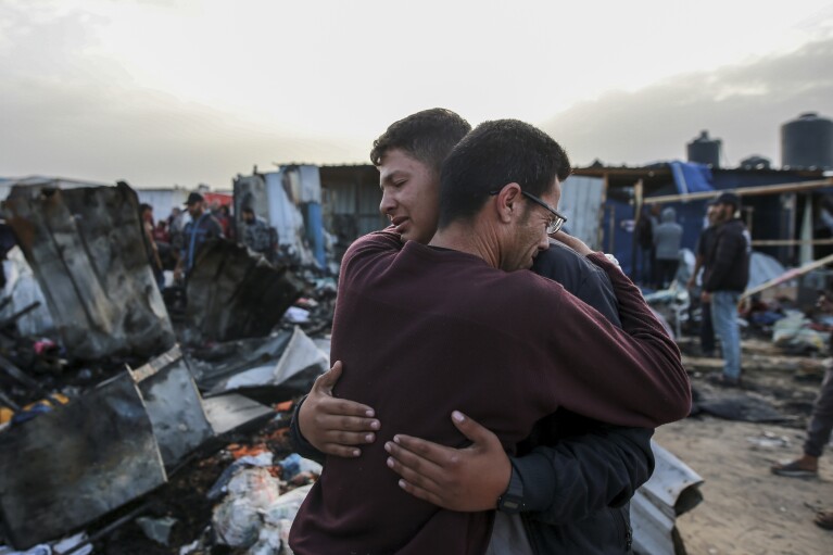 رد فعل الفلسطينيين بجوار الدمار بعد الغارة الإسرائيلية على مكان إقامة النازحين في رفح، قطاع غزة، يوم الاثنين 27 مايو 2024. قال العاملون في مجال الصحة الفلسطينيون إن الغارات الجوية الإسرائيلية قتلت ما لا يقل عن 35 شخصًا في المنطقة.  وأكد الجيش الإسرائيلي غارة يوم الأحد وقال إنها أصابت منشأة تابعة لحماس وقتلت اثنين من كبار نشطاء حماس.  (صورة AP/جهاد الشرفي)