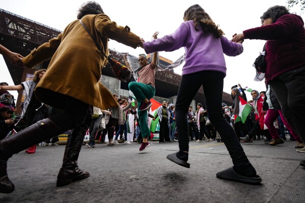 متظاهرون مؤيدون للفلسطينيين يؤدون رقصة الدبكة الشعبية الشامية خلال احتجاج ضد الهجمات الإسرائيلية على غزة، في سانتياغو، تشيلي، 8 يونيو، 2024. (AP Photo / Esteban Felix)