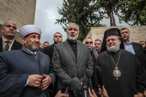صورة أرشيفية تعود إلى 9 يناير 2019 تظهر رئيس المكتب السياسي لحركة حماس إسماعيل هنية (وسط) والمطران أليكسيوس (يمين) يتحدثان إلى الصحافة خلال زيارة هنية لكنيسة القديس برفيريوس بمناسبة احتفالات عيد الميلاد الأرثوذكسي في مدينة غزة، غزة. (علي جاد الله - وكالة الأناضول)