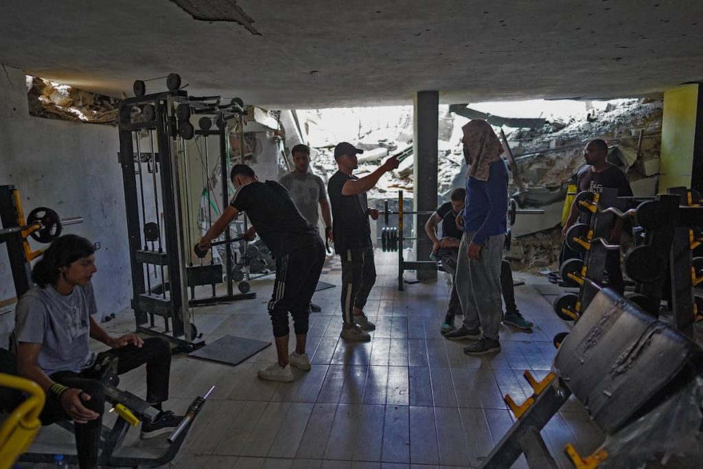في صالة الألعاب الرياضية التي تم انتشالها من بين الأنقاض، يطلق سكان غزة غضبهم على أجهزة رفع الأثقال