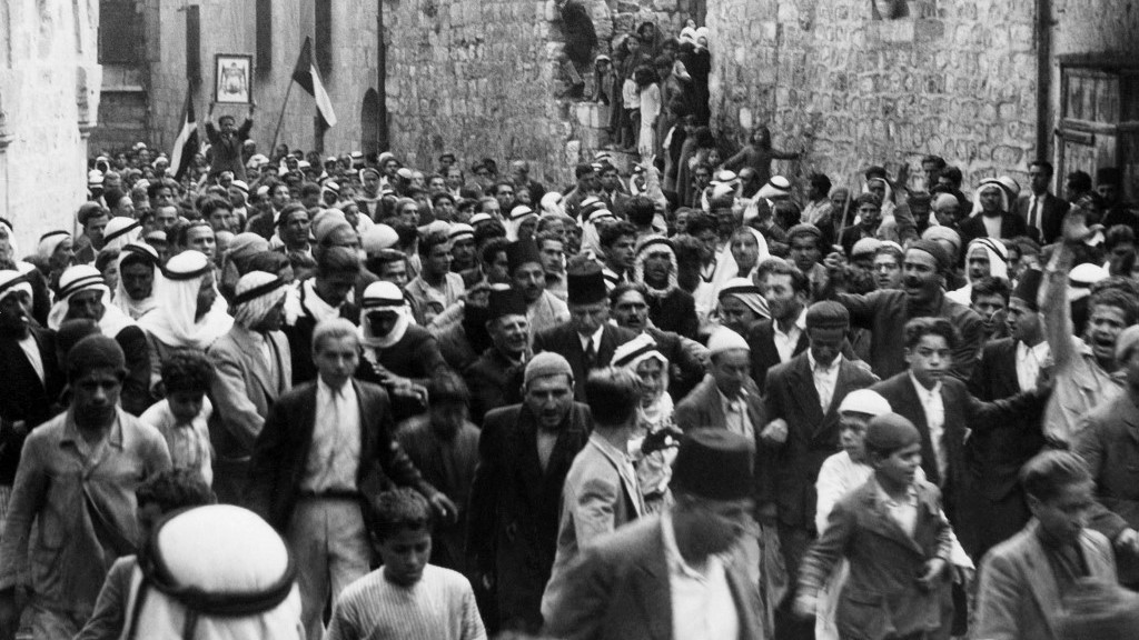 صورة تعود إلى ما قبل عام 1937 أثناء الانتداب البريطاني على فلسطين تظهر عرباً يتظاهرون في البلدة القديمة بالقدس (أ ف ب)