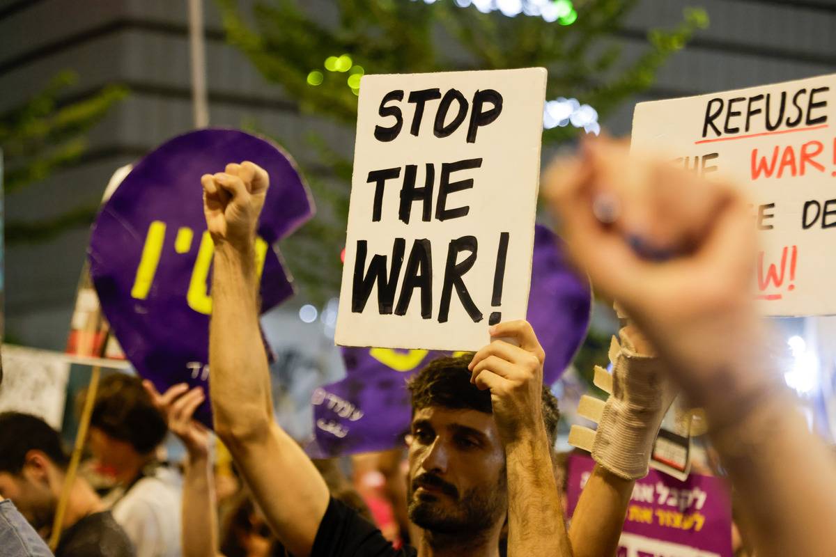 أشخاص يتجمعون مع لافتات وأعلام إسرائيلية للاحتجاج على رئيس الوزراء الإسرائيلي بنيامين نتنياهو وحكومته لعدم التوقيع على اتفاق وقف إطلاق النار مع غزة وللمطالبة باتفاق تبادل الرهائن في تل أبيب، إسرائيل، 28 سبتمبر، 2024. (Nir Keidar-Anadolu Agency)