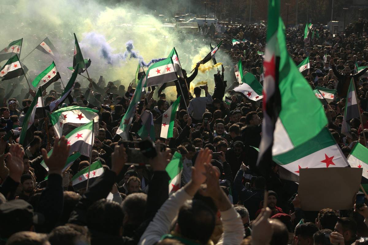 يلوح الناس أعلام المعارضة والتجمع في وسط حلب للاحتفال بانهيار نظام Baath الذي يبلغ طوله 61 عامًا في سوريا ونهاية حكم عائلة الأسد في 13 ديسمبر 2024 ، في حلب ، سوريا (Kasım Rammah-Anadolu Agency)