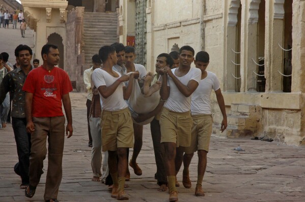 يحمل المتطوعون ضحية تدافع في جودبور ، الهند ، الثلاثاء ، 30 سبتمبر 2008. (صورة AP ، ملف)