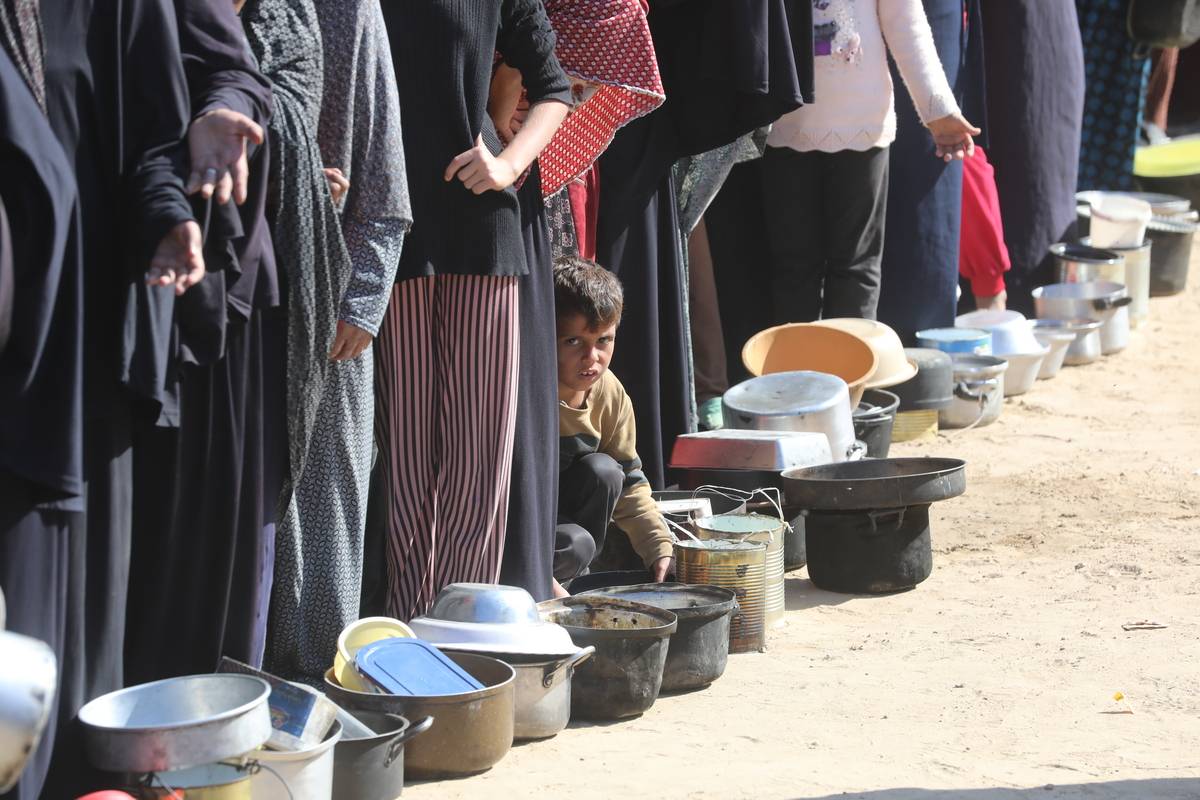 فلسطينيون، بينهم أطفال، ينتظرون استلام المواد الغذائية التي وزعتها منظمة إغاثة في دير البلح، غزة، 18 نوفمبر، 2024. (حسن جدي – وكالة الأناضول)