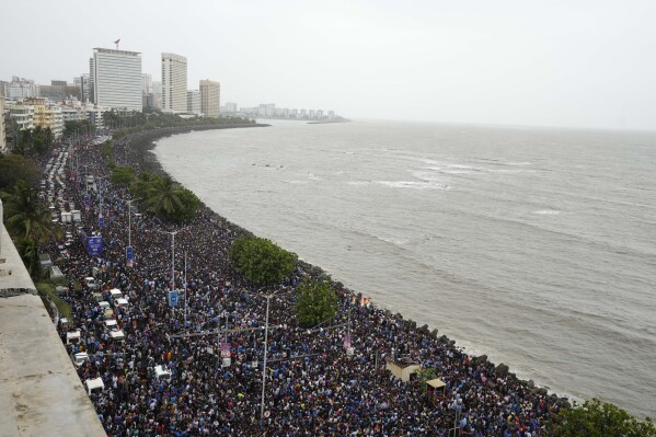 الحشد ينتظر الوصول إلى فريق فريق الكريكيت في الهند بالقرب من ملعب Wankhede في Marine Drive في مومباي ، الهند ، الخميس ، 4 يوليو 2024. (AP Photo/Rajanish Kakade)