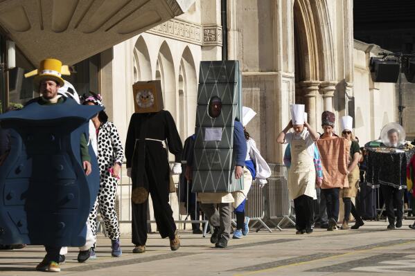 موكب المنافسين في الأزياء خلال سباق الفطيرة التقليدية من قبل شركات الشركات في Guildhall في لندن ، الثلاثاء ، 4 مارس 2025. (AP Photo/Frank Augstein)