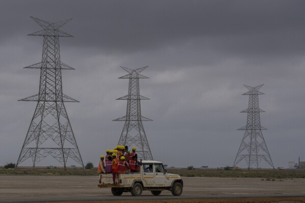 يسافر العمال في مركبة باتجاه موقع بناء حديقة الطاقة المتجددة في Adani Green Energy Limited في صحراء سولت في قرية كريم شاهي ، بالقرب من خافدا ، منطقة بهوج بالقرب من الحدود الهندية الباكستانية في ولاية غوجارات الغربية ، الهند ، في 21 سبتمبر ، 2023. (AP Photo Maqbool ، ملف) ، ملف)