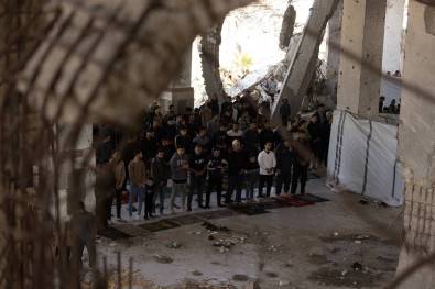 الفلسطينيون يتجمعون بين أنقاض مسجد الإمام شافي لأداء صلاة الجمعة الثانية لشهر رمضان في حي آل زايون في غزة في 14 مارس 2025.