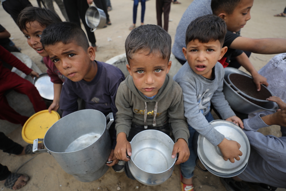 يتلقى الفلسطينيون وجبات ساخنة موزعة من قبل المنظمات الخيرية وسط الهجمات الإسرائيلية المستمرة والحصار الكلي ، في مدينة غزة ، وسط غزة في 02 مايو ، 2025 (Dawoud Abo Alkas - Anadolu Agency)