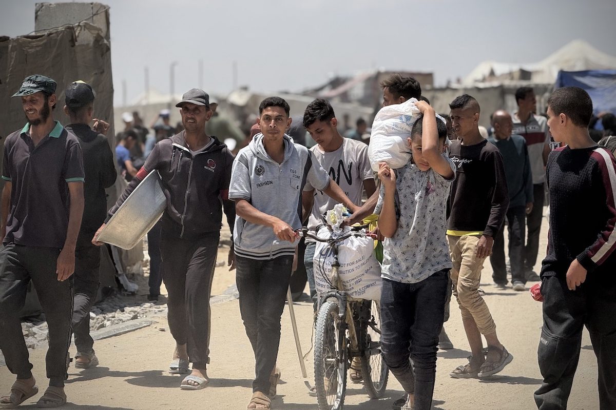يتدفق الفلسطينيون إلى نقطة التوزيع التي تسيطر عليها "مؤسسة الإغاثة الإنسانية في غزة" في قطاع غزة الجنوبي لتلقي المساعدة في اليوم الثاني من توزيع المساعدات في رفه ، غزة في 28 مايو 2025.