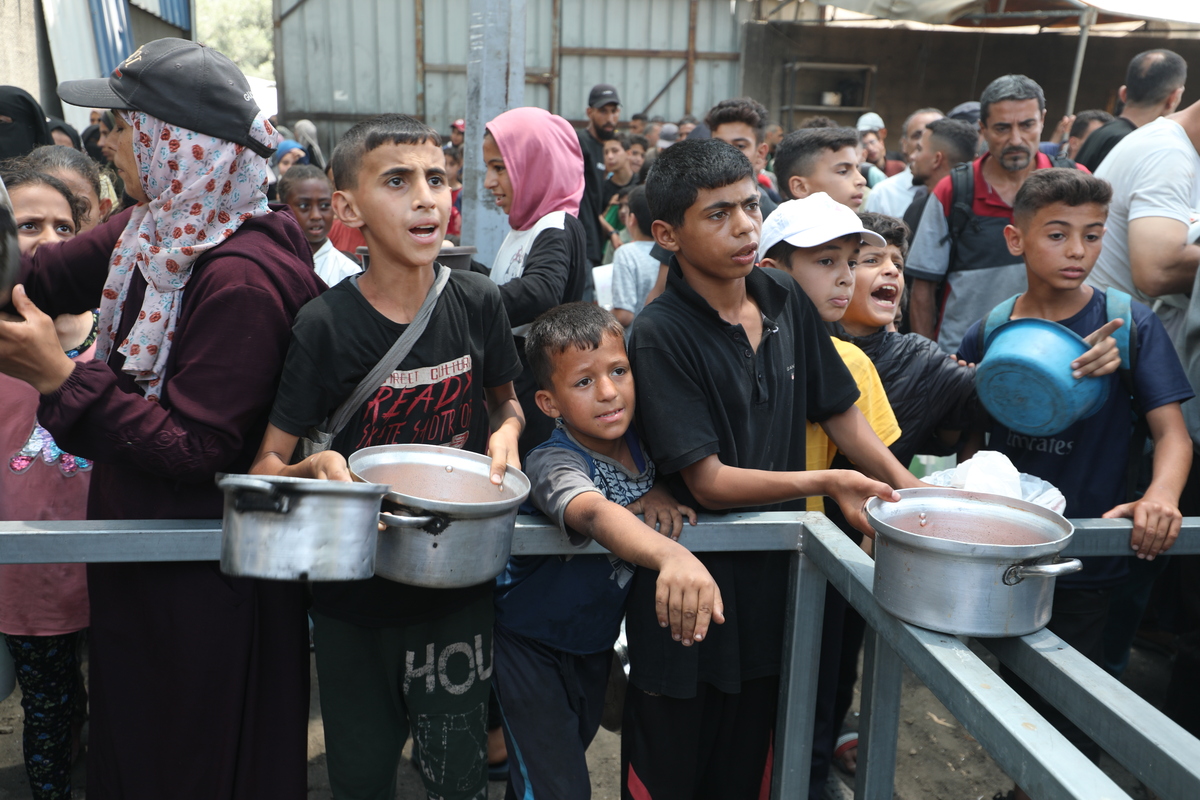 ينتظر الفلسطينيون لتلقي الوجبة الساخنة ، التي توزعتها المنظمات الخيرية ، حيث يقضي الناس العيد آدها في ظل الحصار الإسرائيلي والهجمات في مدينة غزة ، غزة في 7 يونيو 2025.