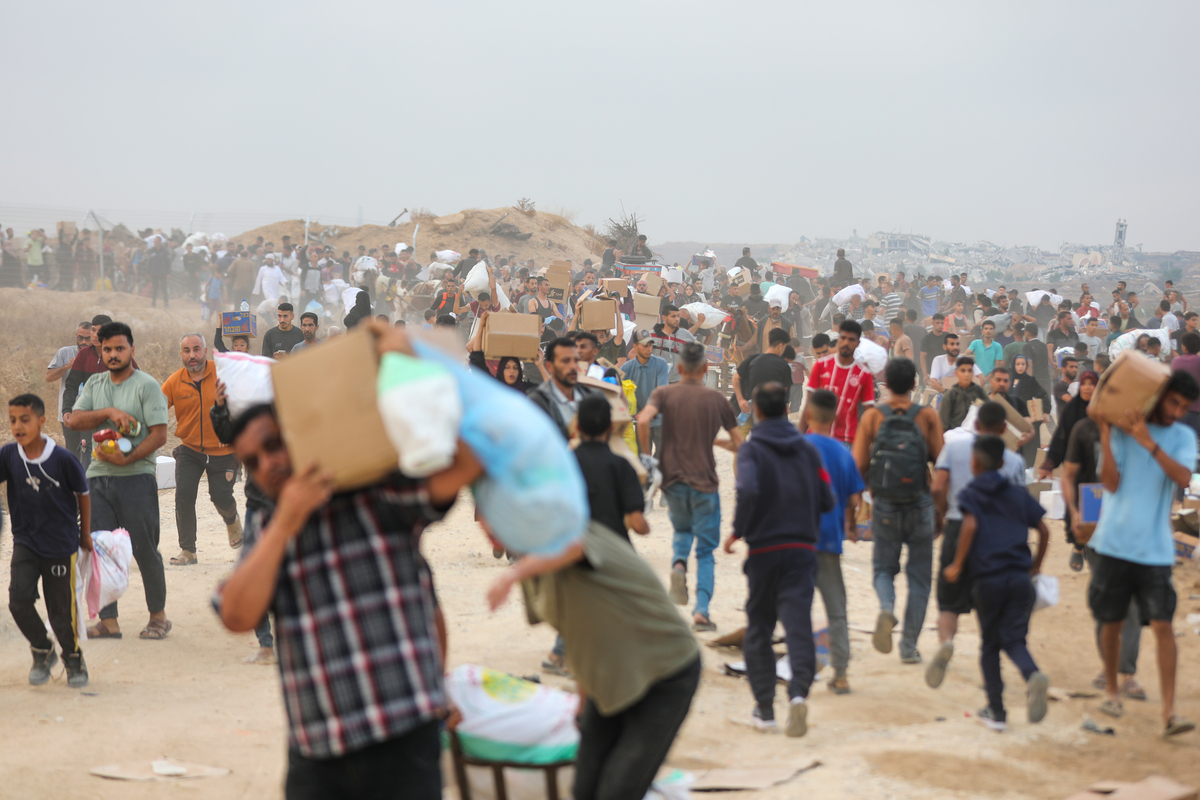 يتدفق الفلسطينيون إلى نقطة توزيع المساعدات في ممر Netzarim في قطاع غزة الوسطى في 8 يونيو 2025. (Moiz Salhi - Anadolu Agency)