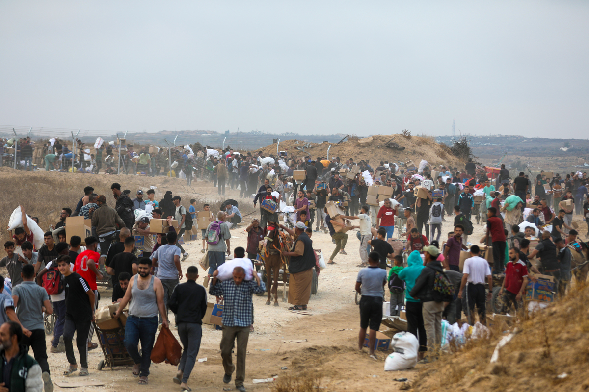 يتدفق الفلسطينيون إلى نقطة توزيع المساعدات في ممر Netzarim في قطاع غزة الوسطى في 8 يونيو 2025. (Moiz Salhi - Anadolu Agency)