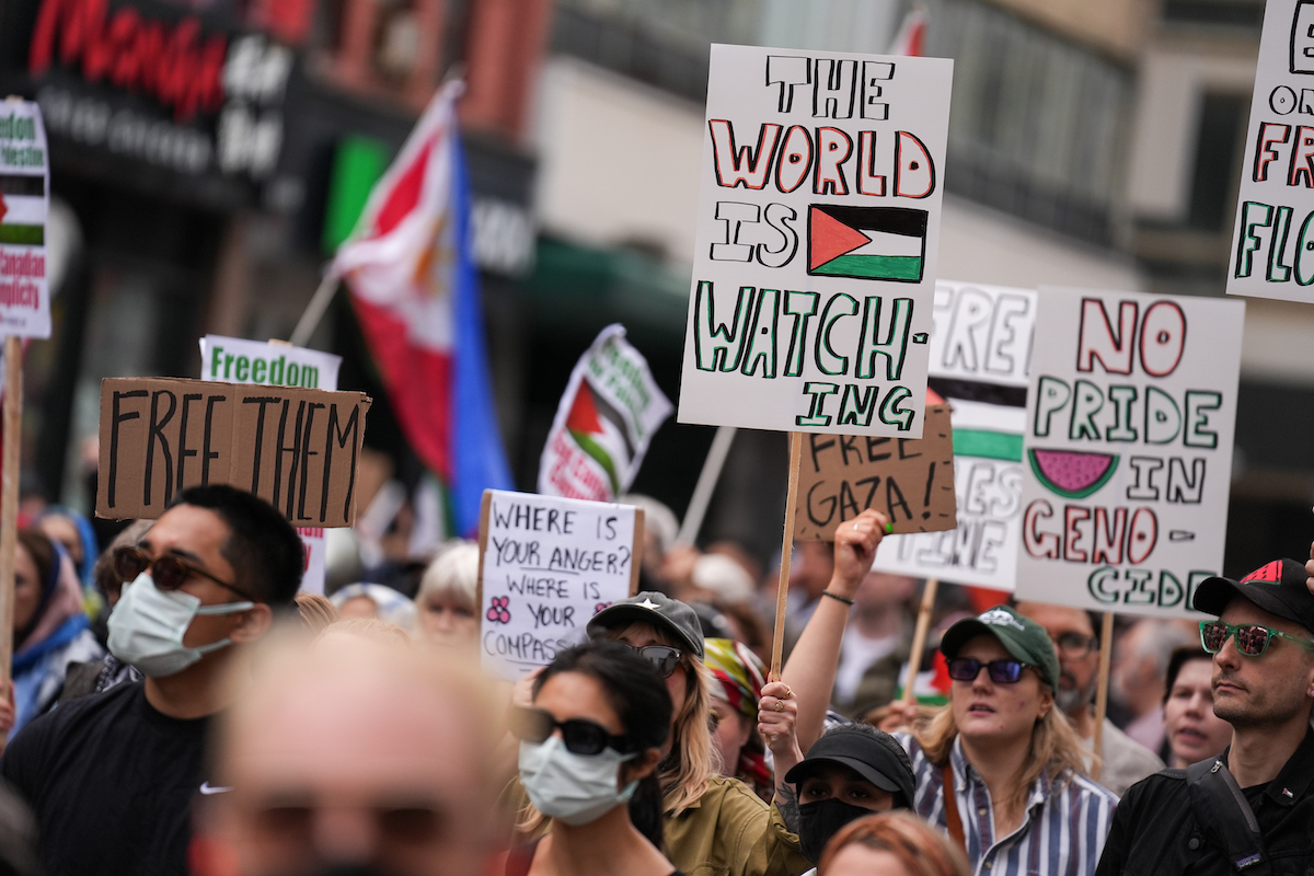 يشارك الأشخاص الذين يحملون الأعلام واللافتات الفلسطينية في احتجاج ضد اعتراض إسرائيل لسفينة الإسعافات