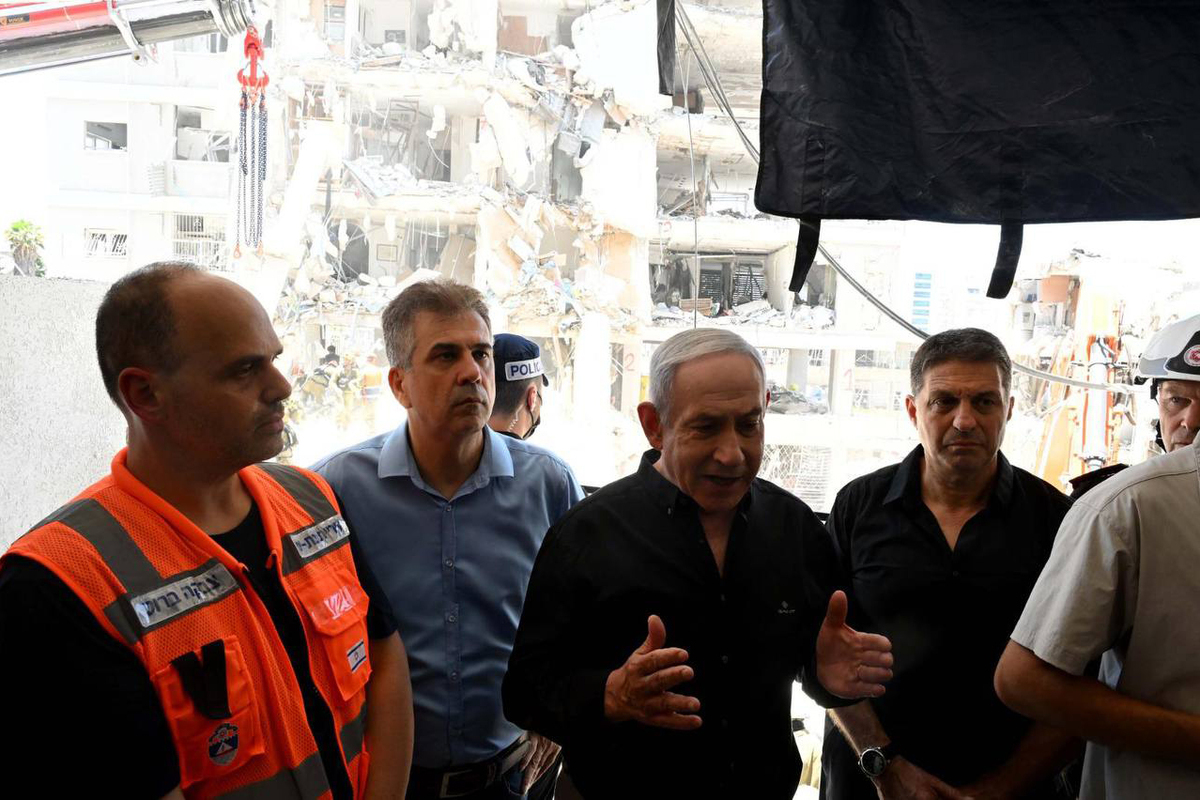 رئيس الوزراء الإسرائيلي بنيامين نتنياهو (2 ر) يتفقد المباني السكنية التي هدمت بعد شن هجوم صاروخي إيران ضد إسرائيل في بات يام في 15 يونيو 2025.