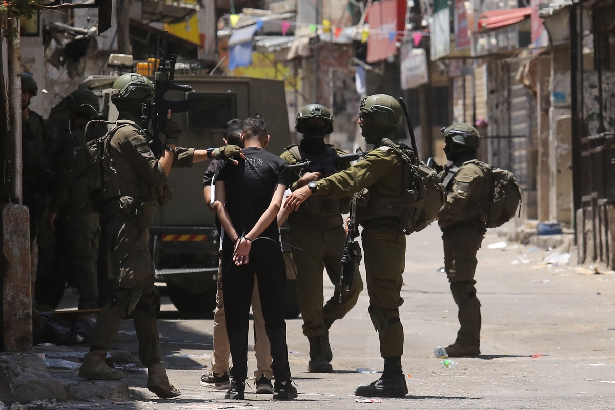 احتجزت القوات الإسرائيلية الفلسطينيين خلال غاراتهم في معسكر بالاتا في نابلوس ، الضفة الغربية في 18 يونيو 2025.