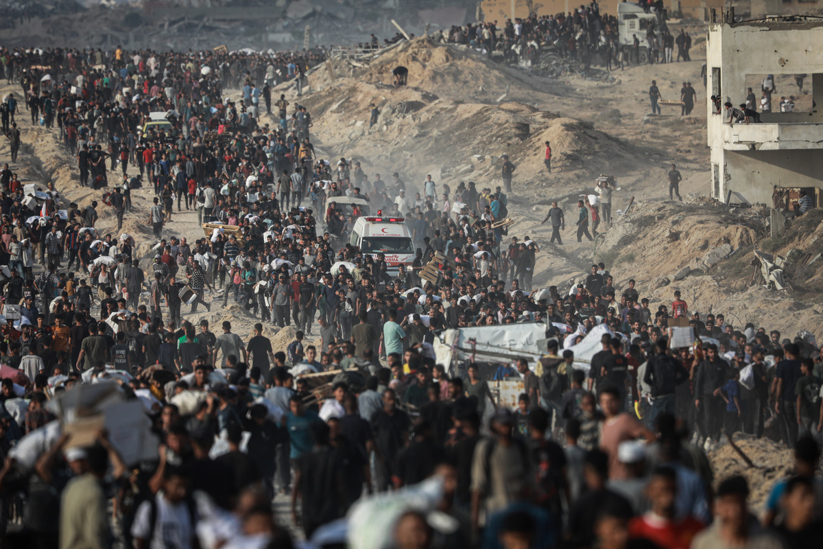يحمل الفلسطينيون أكياس المساعدات في أعقاب هجوم الجيش الإسرائيلي على الفلسطينيين الذين تجمعوا لتلقي المساعدة في منطقة زكيم في مدينة غزة ، غزة في 22 يونيو 2025.