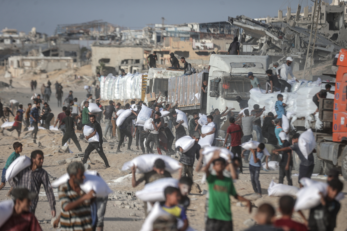 يتلقى الفلسطينيون إمدادات المساعدات بعد أن دخلت شاحنات المساعدة التي أرسلتها الأمم المتحدة في ظل الهجمات الإسرائيلية إلى الحدود الزكيم تحت حماية الفلسطينيين ووصلت إلى المستودعات في الشمال في مدينة غزة ، غزة ، في 25 يونيو 2025 (علي جادو الله - وكالة Anadolu))