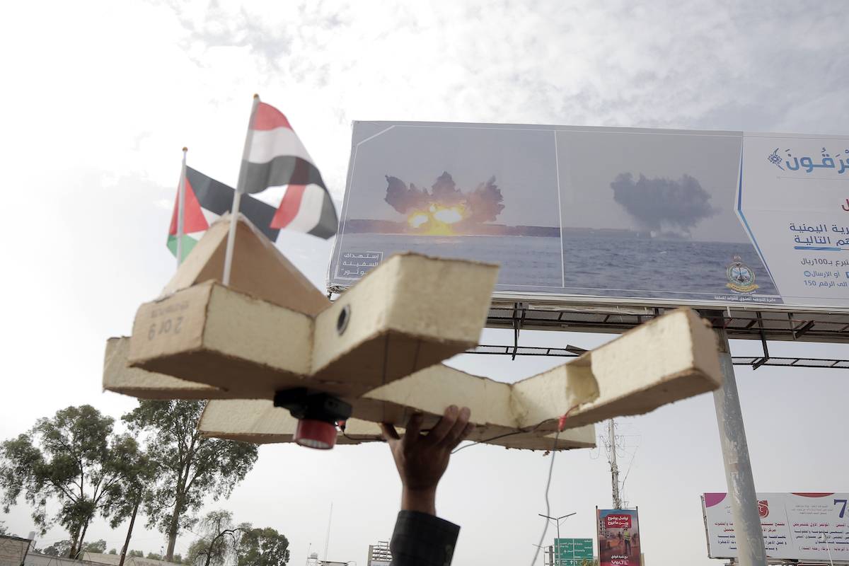 يرفع المتظاهر طائرة بدون طيار وهمية مع أعلام اليمن والفلسطين تحت لوحة إعلانية تصور صورة لاستهداف سفينة مرتبطة بإسرائيل من قبل قوات الحوثيين اليمنية في البحر الأحمر ، خلال مظاهرة تم عرضها ضد آخر الهجمات الهوائية التي تضرب مدينة هادايد في يمنس ، في يوليو ، في يوليو 2024. (محمد حامود/غيتي إيرش)