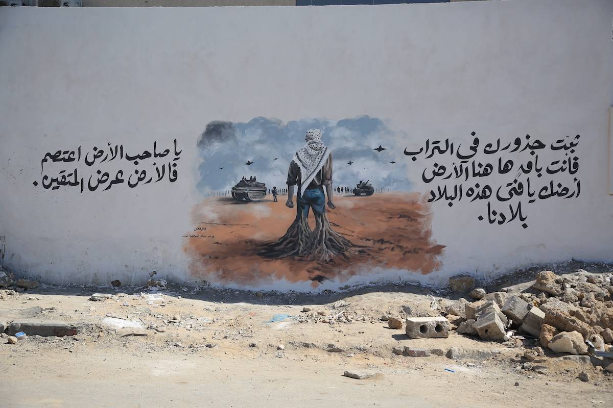 الرسام الفلسطيني فازل تافش ، الذين يعيشون في غزة ، يخلق عملًا فنيًا يرمز إلى مقاومة الناس وربطهم بأراضيهم على جدار مستشفى المعمدانيين المعمدانيين في هجمات إسرائيل المستمرة على غزة في الذكرى السنوية الأولى ، في مدينة غزة ، غزة في 10 أكتوبر 2024.