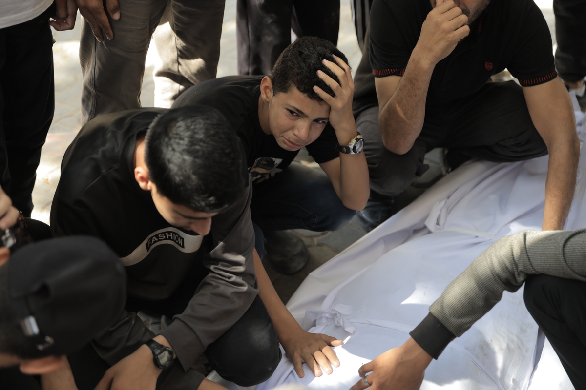 يحزن الأقارب بجوار الجثث ملفوفة في أكياس في مستشفى الشيفا بعد ضربة إسرائيلية على الفلسطينيين الذين ينتظرون المساعدة في منطقة السودانية في شمال غزة ، في 14 يونيو 2025 (أحمد جهاد إبراهيم العربي-وكالة أندولو))