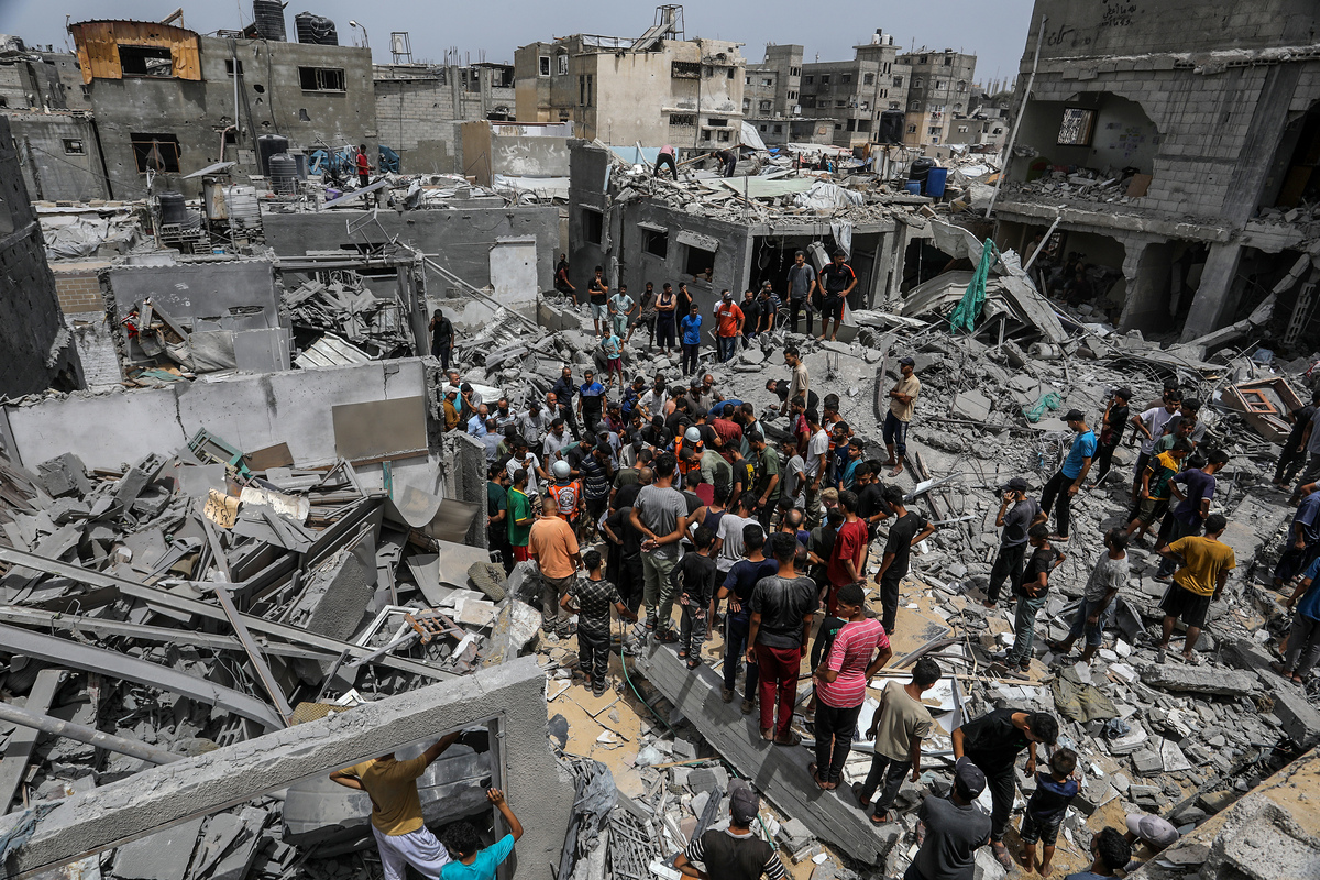 يقوم السكان وفرق الدفاع المدني بإجراء عمليات البحث والإنقاذ بين فرك المباني المدمرة بعد الهجوم الإسرائيلي في معسكر خان يونيس للاجئين في خان يونيس ، غزة في 1 يوليو 2025.