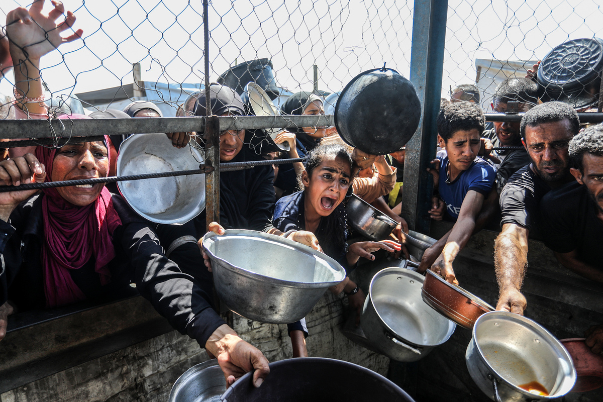 يتجمع الفلسطينيون لتلقي الطعام في 03 يوليو 2025 في خان يونيس ، غزة. يكافح الآلاف من الفلسطينيين مع الجوع بسبب الهجمات الإسرائيلية على غزة وعدم وجود مساعدة إنسانية. في خان يونيس ، قامت منظمة خيرية بتوزيع الطعام على الفلسطينيين النازحين في منطقة ماواسي. (عابد رحيم خاتيب - وكالة أنادوولو)