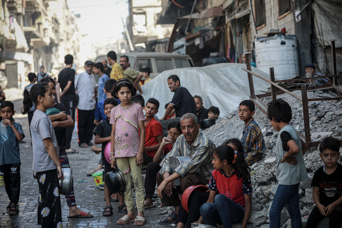 يشكل العديد من الفلسطينيين ، بمن فيهم الأطفال ، تدافعًا للحصول على طعام موزعة من قبل منظمة خيرية ، في 7 يوليو 2025 في مدينة غزة ، غزة. (Abdalhkem Abu Riash - ANADOLU Agency)
