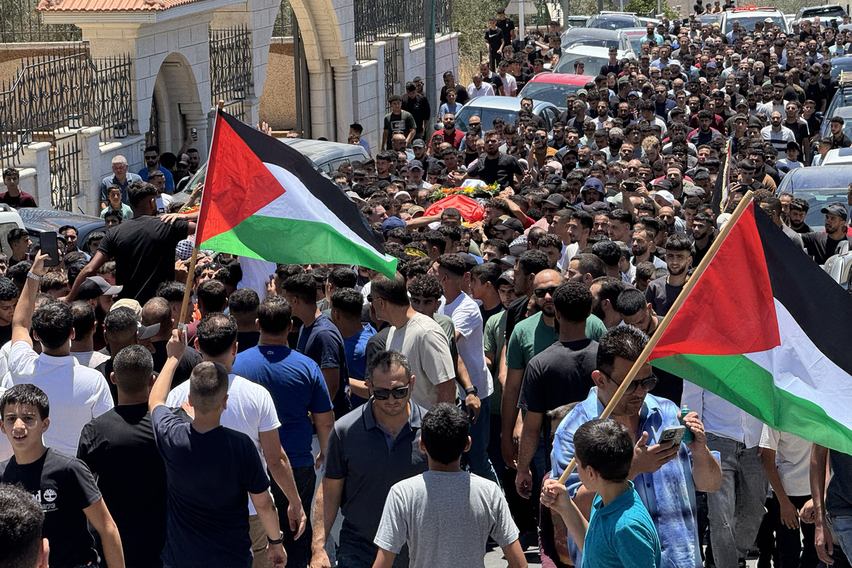 يحضر الأشخاص الذين يحملون الأعلام الفلسطينية جنازة اثنين من الفلسطينيين الذين قتلوا على يد المستوطنين اليهود غير الشرعيين في حي الشارقية في 13 يوليو 2025 ، في رام الله ، الضفة الغربية. (Hisham KK Abu Shaqra - ANADOLU Agency)