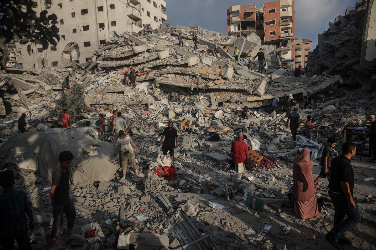 يتفقد الفلسطينيون الأضرار بعد الغارة الجوية الإسرائيلية ، التي استهدفت مبنى سكني مكون من 9 طوابق في حي تل العلة في قطاع غزة في 15 يوليو 2025 (عبدكيم أبو ريش-وكالة Anadolu)