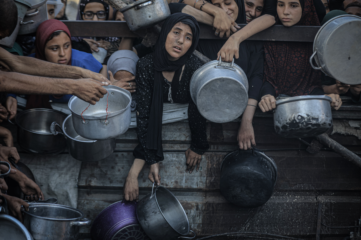 فلسطينيون ، بما في ذلك الأطفال ، الذين يكافحون للوصول إلى الطعام بسبب الحصار الإسرائيلي والهجمات المستمرة على قطاع غزة ، ينتظرون في طابور لتلقي وجبات ساخنة موزعة من قبل المنظمة الخيرية في مدينة غزة ، غزة في 16 يوليو 2025.