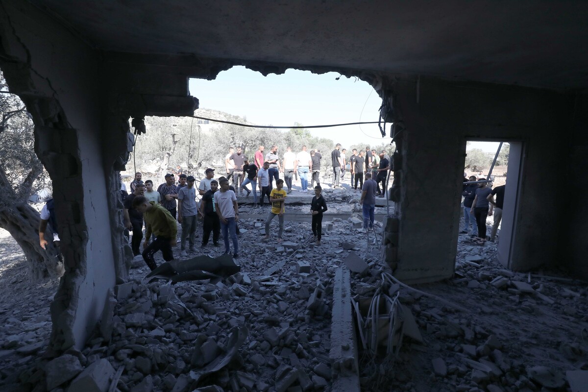 يتفقد الفلسطينيون حطامًا لمبنى بعد أن فجر الجيش الإسرائيلي ثلاثة منازل تابعة للفلسطينيين الذين قتلوا في السابق القوات الإسرائيلية في جينين ، الضفة الغربية في 17 يوليو 2025.