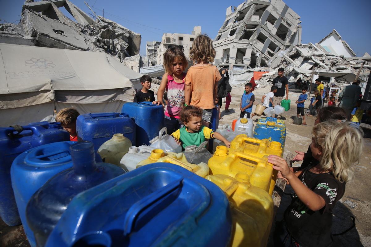 الفلسطينيون النازحون في مدينة غزة يملأون جيريكان من المياه التي تسلمها الناقلات لتلبية احتياجاتهم اليومية في 17 يوليو 2025.