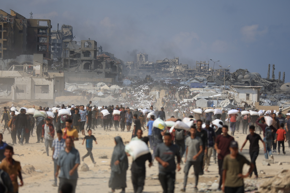 يحمل الفلسطينيون المساعدات التي تم الحصول عليها في زيكيم مع عودة أسرهم بالقرب من السودانيا في شمال غزة في 20 يوليو 2025.