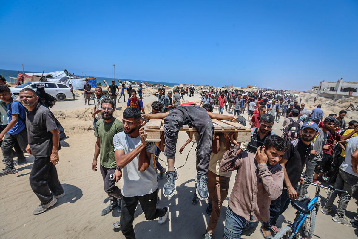 يحمل الفلسطينيون الفلسطينيون الجرحى بعد أن هاجم القوات الإسرائيلية حشدًا تجمع لتلقي المساعدة في زكيم ، شمال غزة في 22 يوليو 2025.