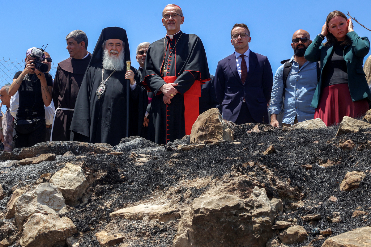 البطريرك اللاتيني للقدس بيرباتيستا بيزابالا والبطريرك الأرثوذكسي اليوناني في القدس ثيوفيلوس الثالث يقفون معًا خلال زيارة من رجال الدين الرئيسيين في العديد من الطوائف المسيحية في كنيسة القديس جورج في القرن الخامس ، (تصوير القديس في القديس الفلسطيني ، Jaafar/AFP عبر Getty Images)