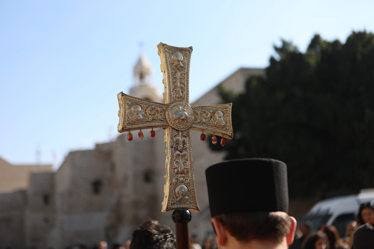 تدخل البطريرك الأرثوذكسي اليوناني في القدس ثيوفيلوس الثالث إلى كنيسة المهد في مجمع كنيسة المهد المشترك في مدينة بيت لحم التوراتية في الضفة الغربية المحتلة ، حيث تمثل المسيحيون الشرقيون عشية عيد الميلاد في 6 يناير 2025.