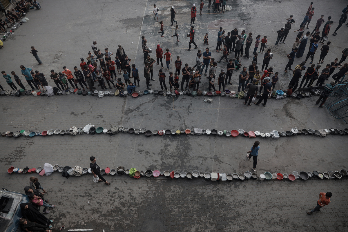 يشكل الفلسطينيون ، الذين يكافحون مع الجوع ، خطًا لتلقي وجبات ساخنة في حي التونو في غزة في 31 يوليو 2025. (عبد الله أبو ريش - وكالة Anadolu)