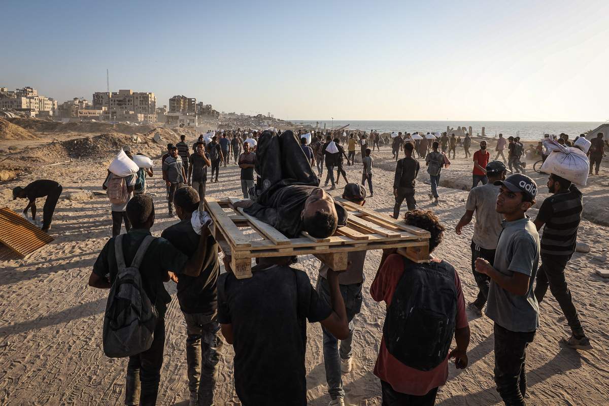 يحمل الفلسطينيون جثث الفلسطينيين الذين قتلوا على أيدي القوات الإسرائيلية وهم يفتحون النار على الحشد في انتظار المساعدات الإنسانية في منطقة زيكيم في شمال غزة ، في 03 أغسطس ، 2025.