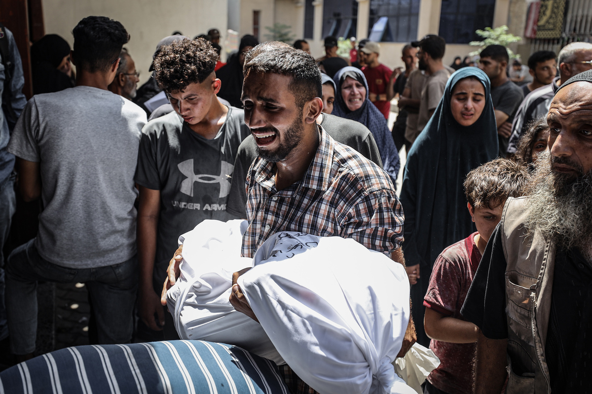 أقارب وأحباء الفلسطينيين ، الذين فقدوا حياتهم في هجوم إسرائيلي في حي Ez -Zeytun ، يحزنون على المتوفى حيث يتم نقل الجثث إلى مستشفى العميدي الإلهلي لصالح جنازة في مدينة غزة الشرقية ، غزة في 6 أغسطس ، 2025.