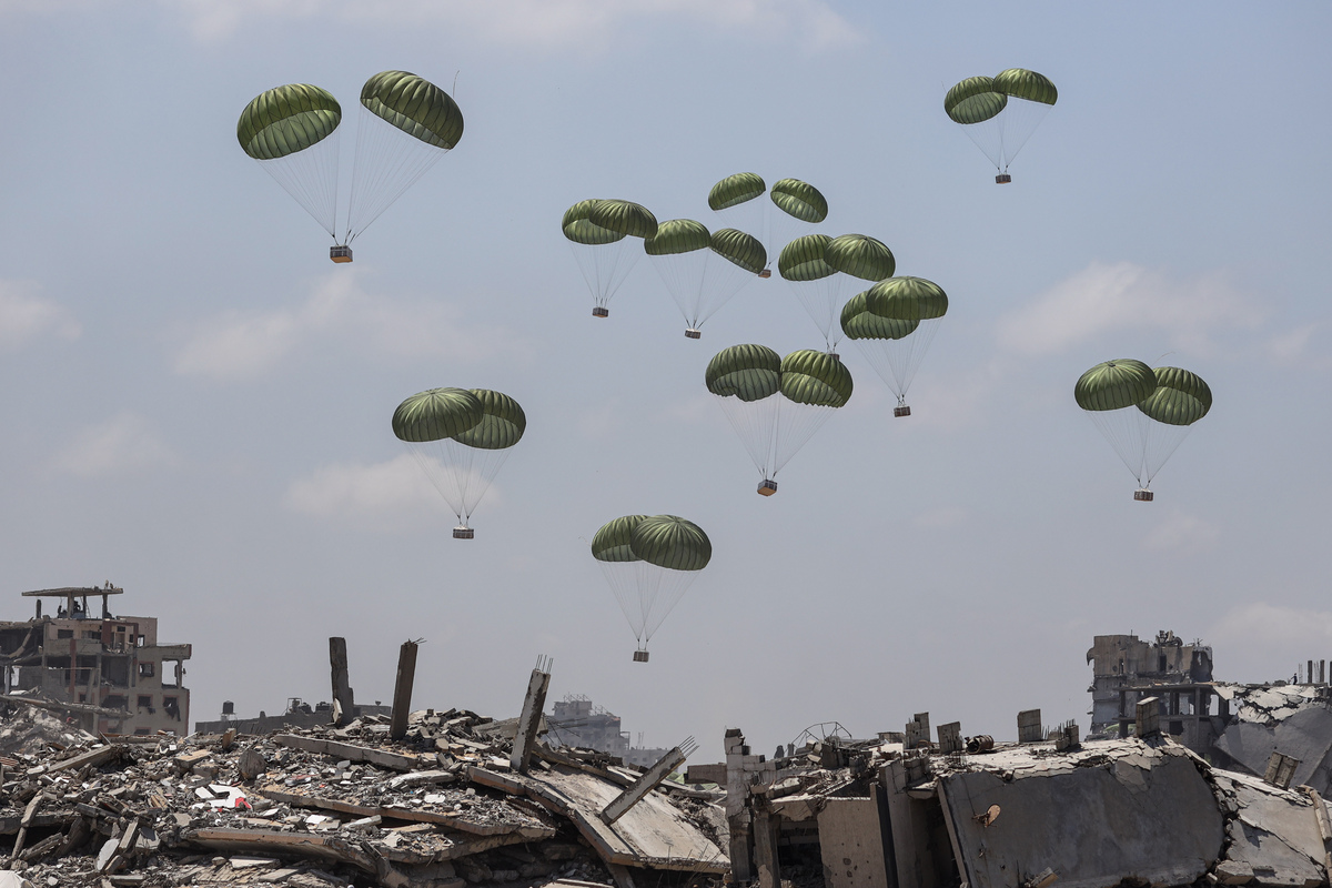 يتدفق الفلسطينيون إلى المنطقة التي تعلق بها الطائرات Airdrop الإنسانية المرتبطة بالمظلات في شمال مدينة غزة ، غزة في 07 أغسطس ، 2025 (Khames Alrefi - ANADOLU Agency)