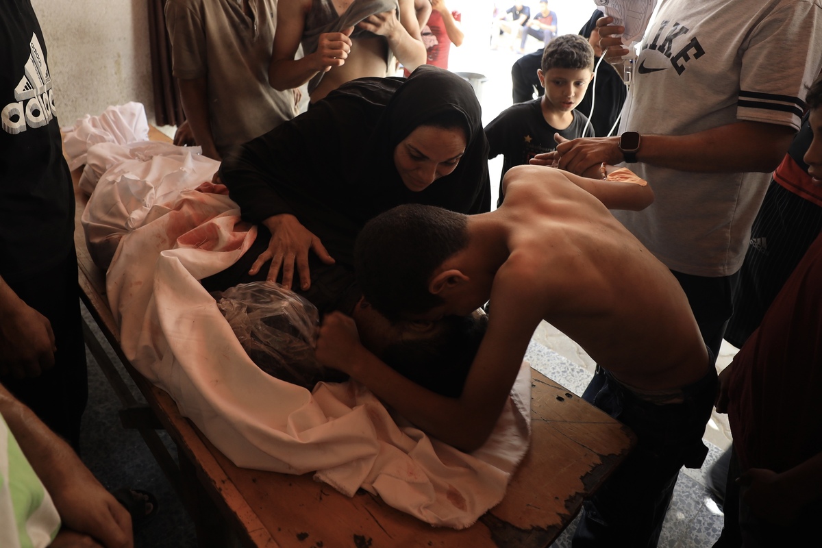 يقترب الأقارب بالقرب من جثة القتلى الفلسطينية في هجوم إسرائيلي على منزل في شارع التالاثيني إلى مستشفى العمي (المعمدانيين) خلال إجراءات الجنازة في مدينة غزة ، غزة في 14 أغسطس ، 2025.