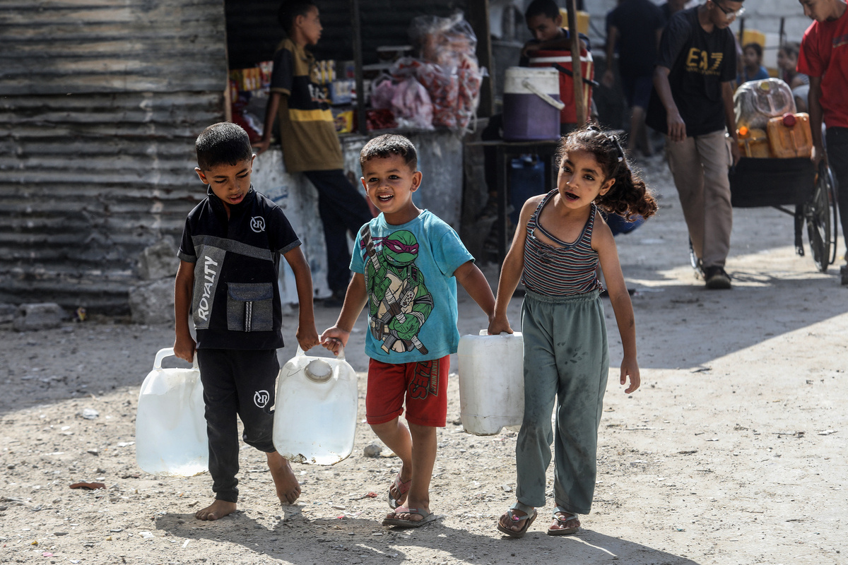 يتلقى الفلسطينيون والأطفال مياه نظيفة من مسجد الشافي ويحملونها إلى خيامهم ، حيث دمر القصف الإسرائيلي المستمر البنية التحتية للجيب ، تاركين السكان دون الوصول إلى المياه النظيفة في خان يونيس ، غزة في 16 أغسطس 2025.